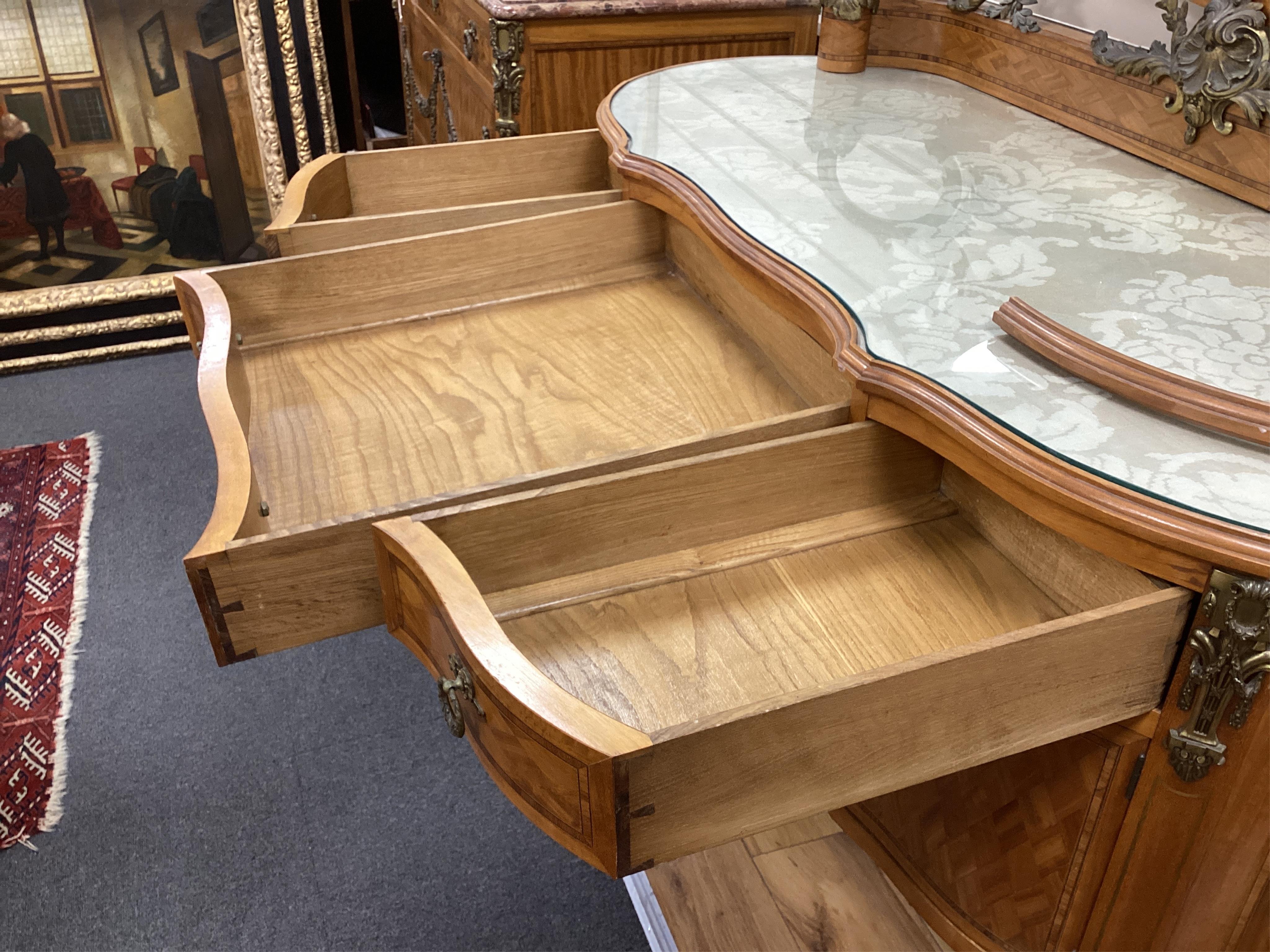 An early 20th century French transitional style gilt metal mounted tulip banded and parquetry inlaid kneehole dressing table, width 115cm, depth 50cm, height 160cm